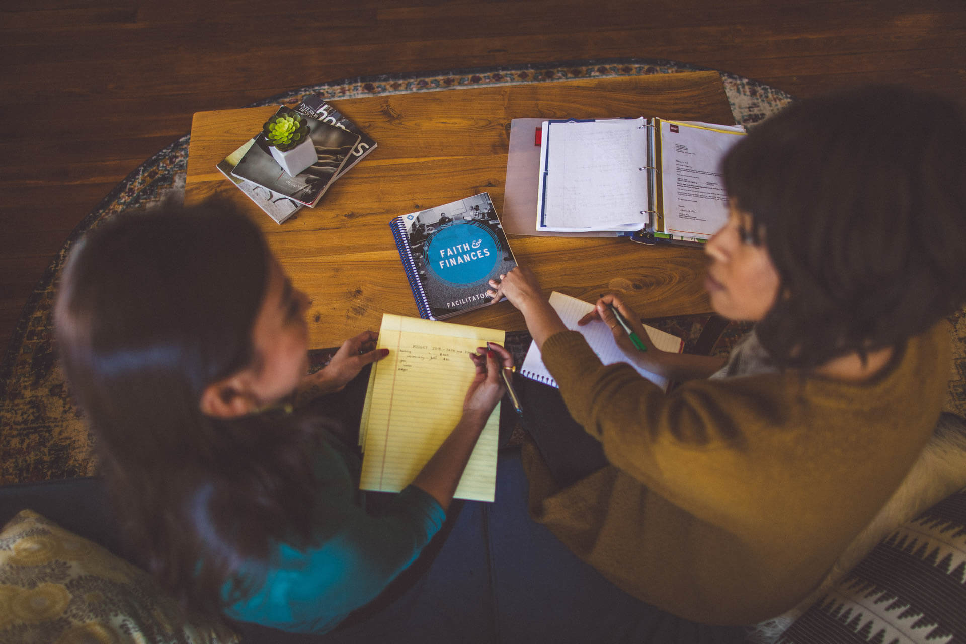 Two women looking at Faith & Finances curriculum